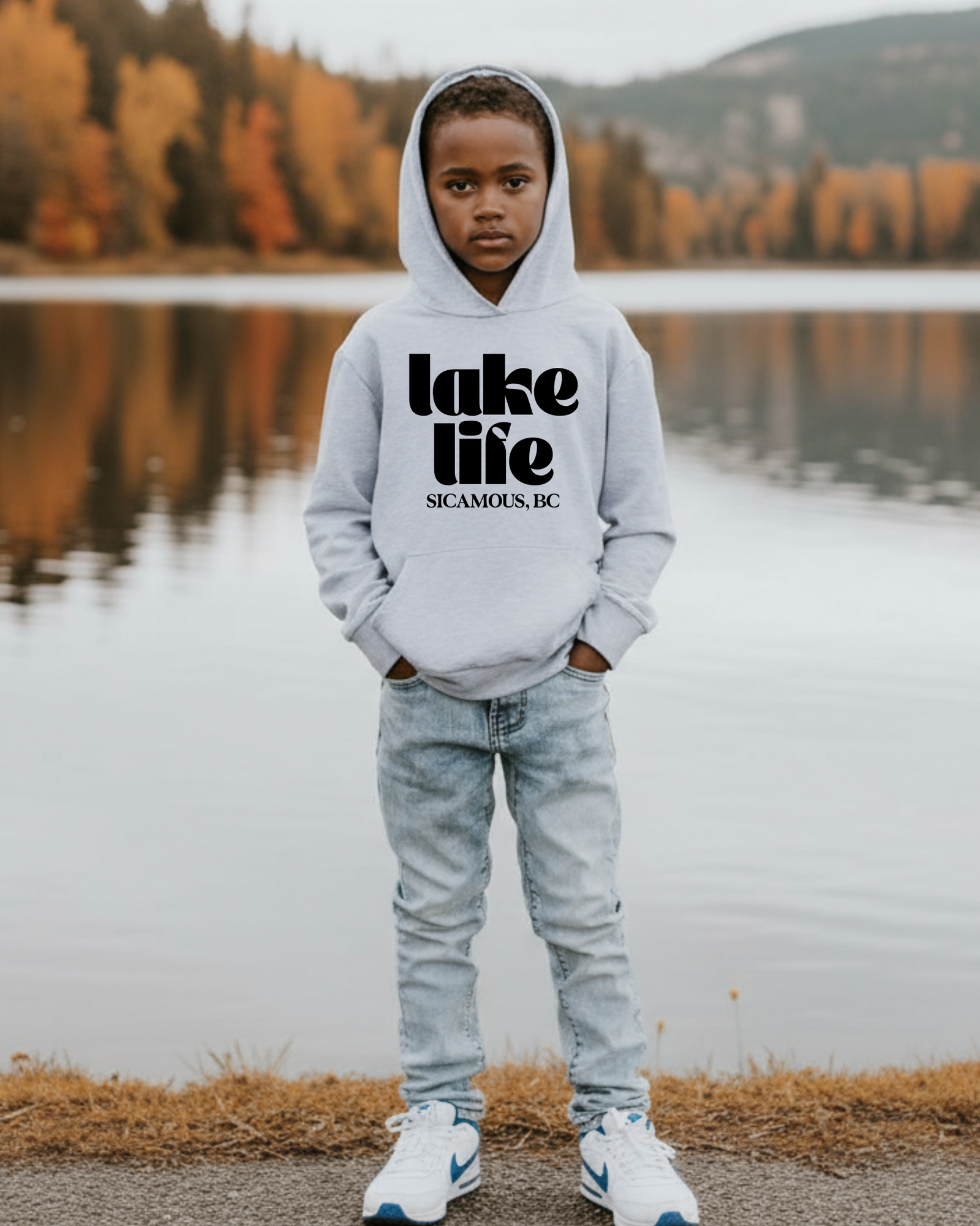 Regenerated boy sitting on a lakeside bench in a navy Lake Life outfit