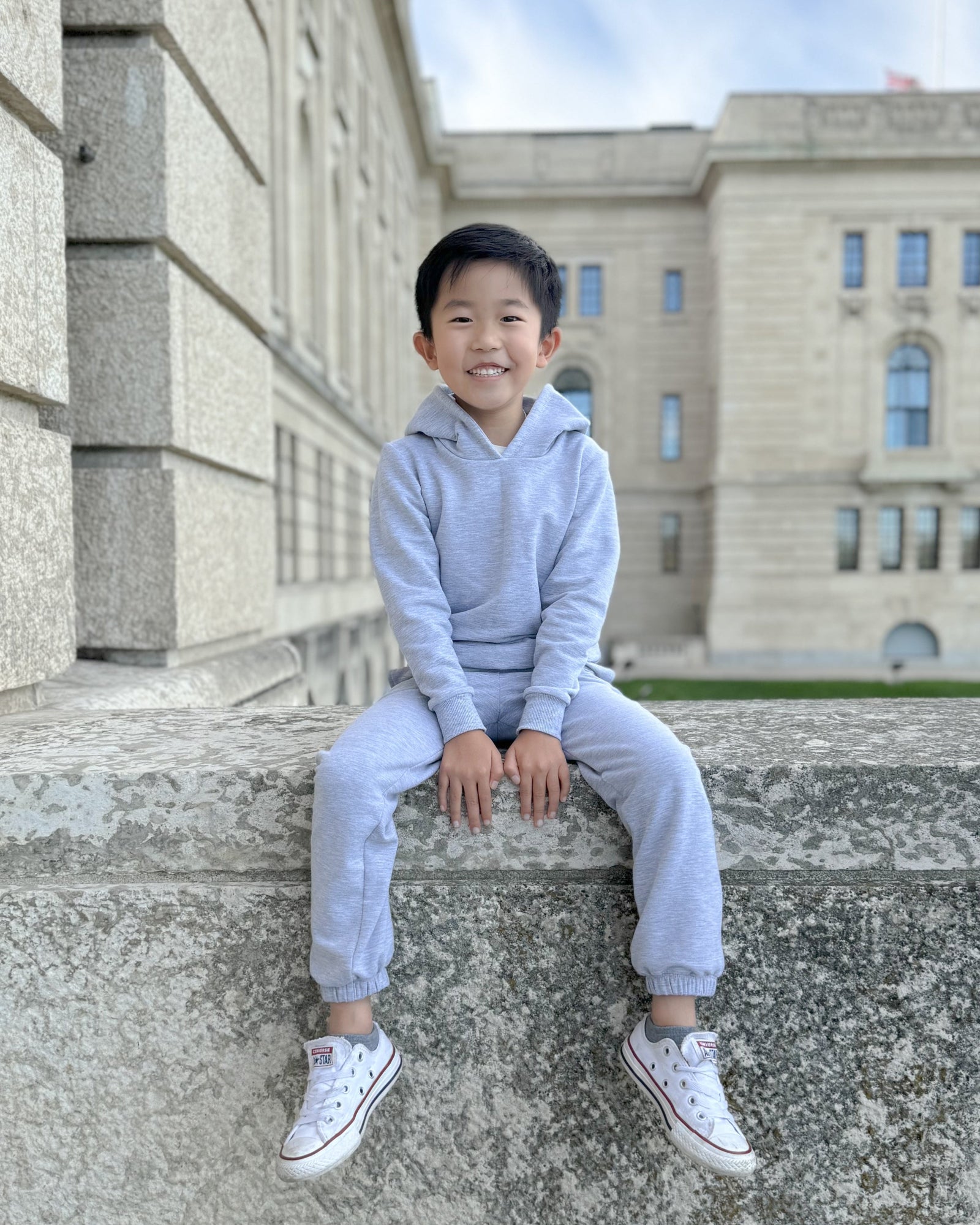 Overhead view of the girl’s charcoal sweatpants, showing their fit, seams and gathered ankles with extra space for a 4:5 crop