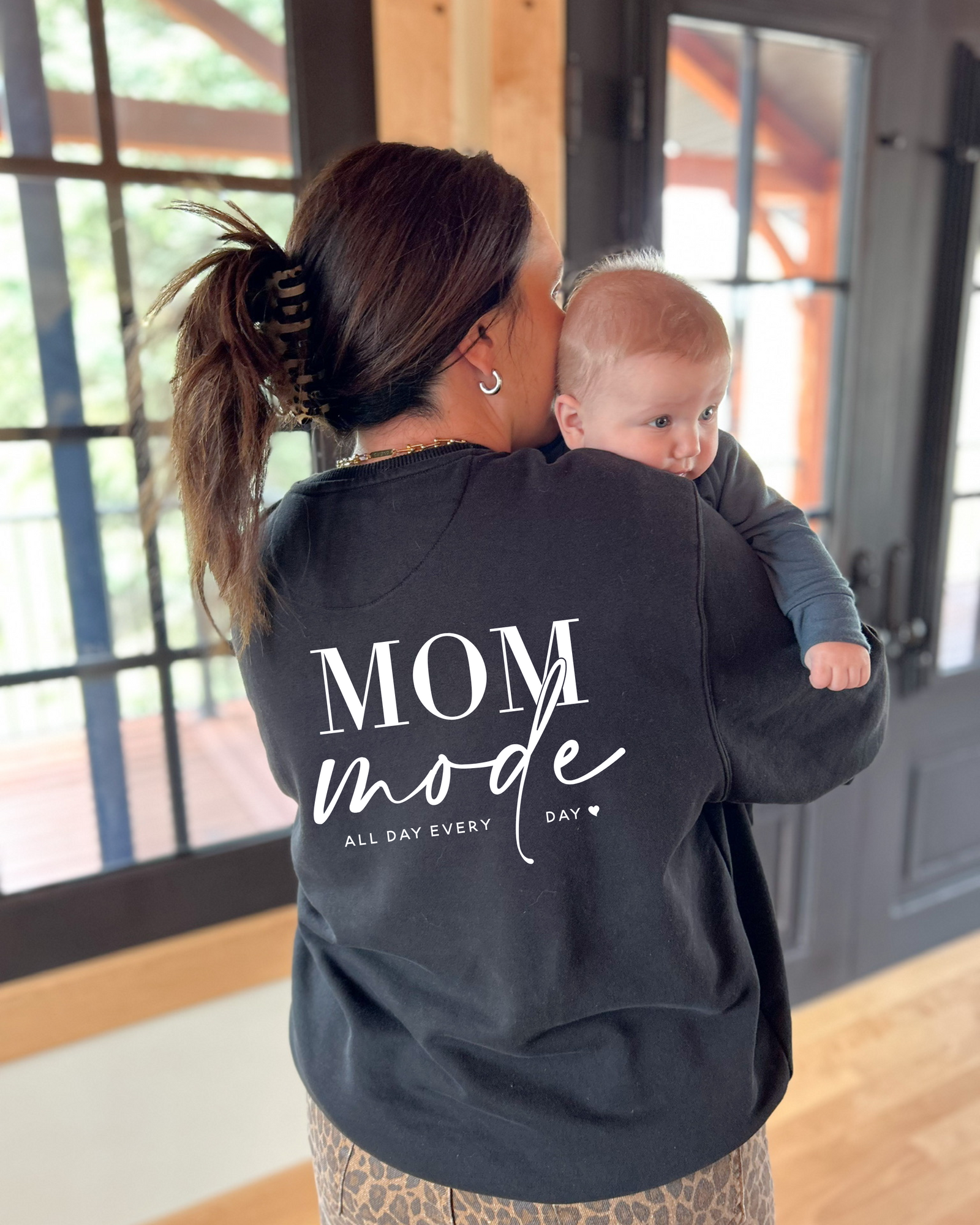 Closer hugging pose highlighting the Mom Mode crewneck