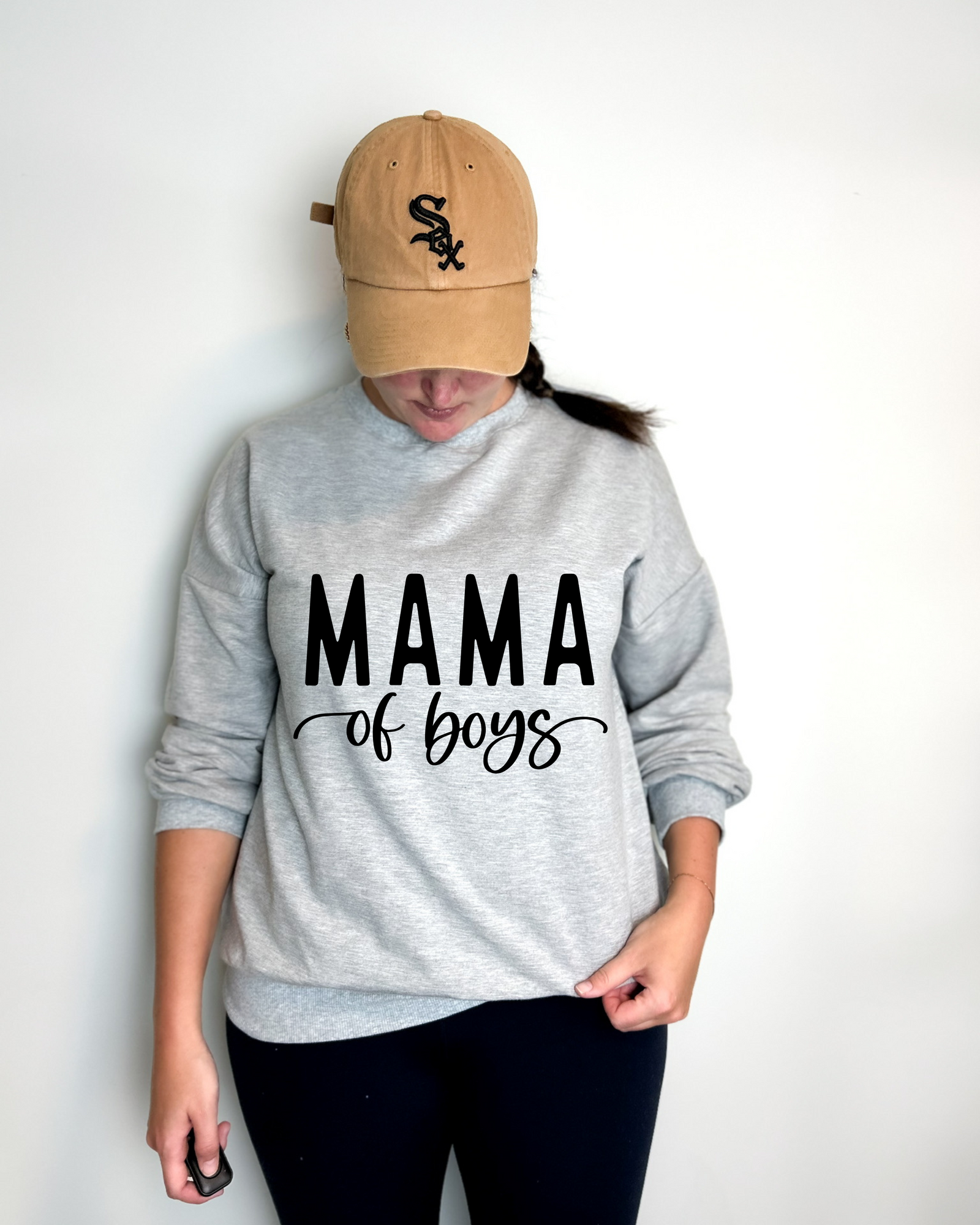 Mom in a black Mama of Boys crewneck walking with two boys