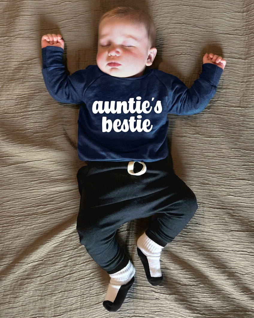 Baby in navy auntie’s bestie sweater with black-and-white socks