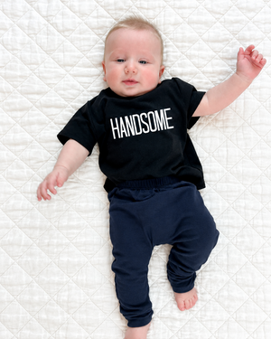 Baby wearing navy pants with extra quilt background for cropping