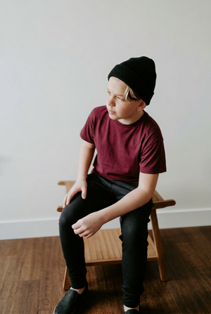 Boy in a burgundy tee with roomier sleeves and warmer, softer facial lighting