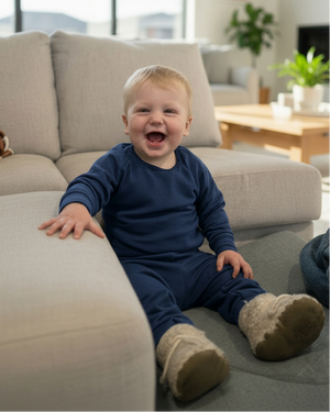 Boy in a matching navy outfit on the sofa