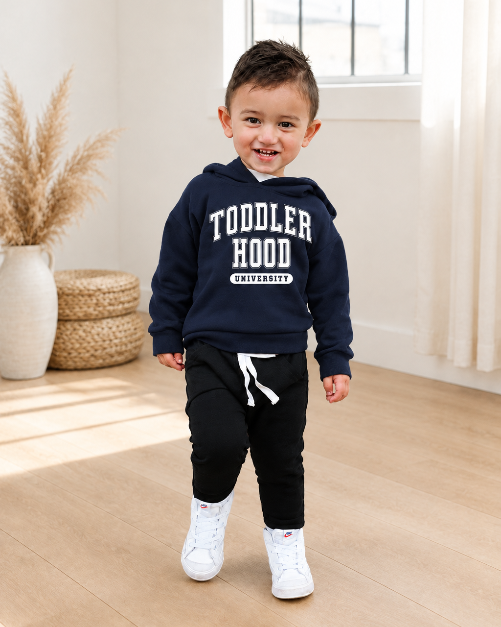 Boy in a navy printed hoodie in a warm neutral studio