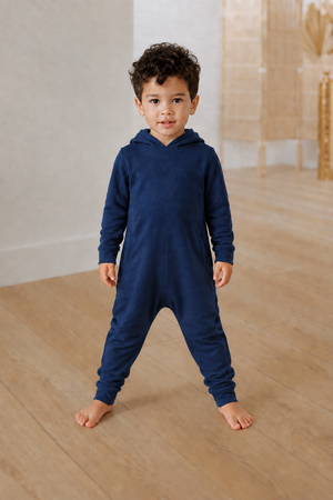 Boy in a navy romper with a more relaxed crotch and leg fit