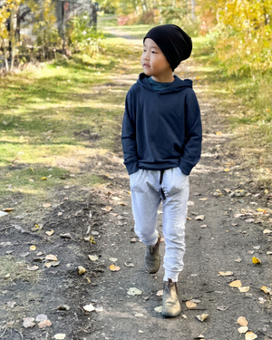 Boy walking on an autumn path in a navy hoodie and black slouchy beanie