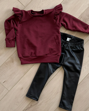 Burgundy Cynthia crewneck with black leggings in the original flat-lay arrangement