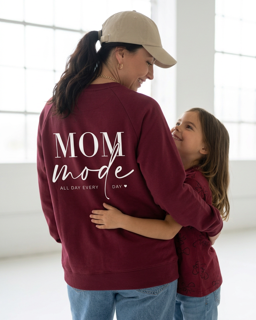 Closer hugging pose highlighting the Mom Mode crewneck