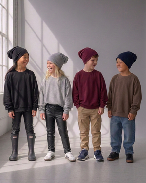 Four kids in lounge sweaters, with both girls wearing black faux leather leggings