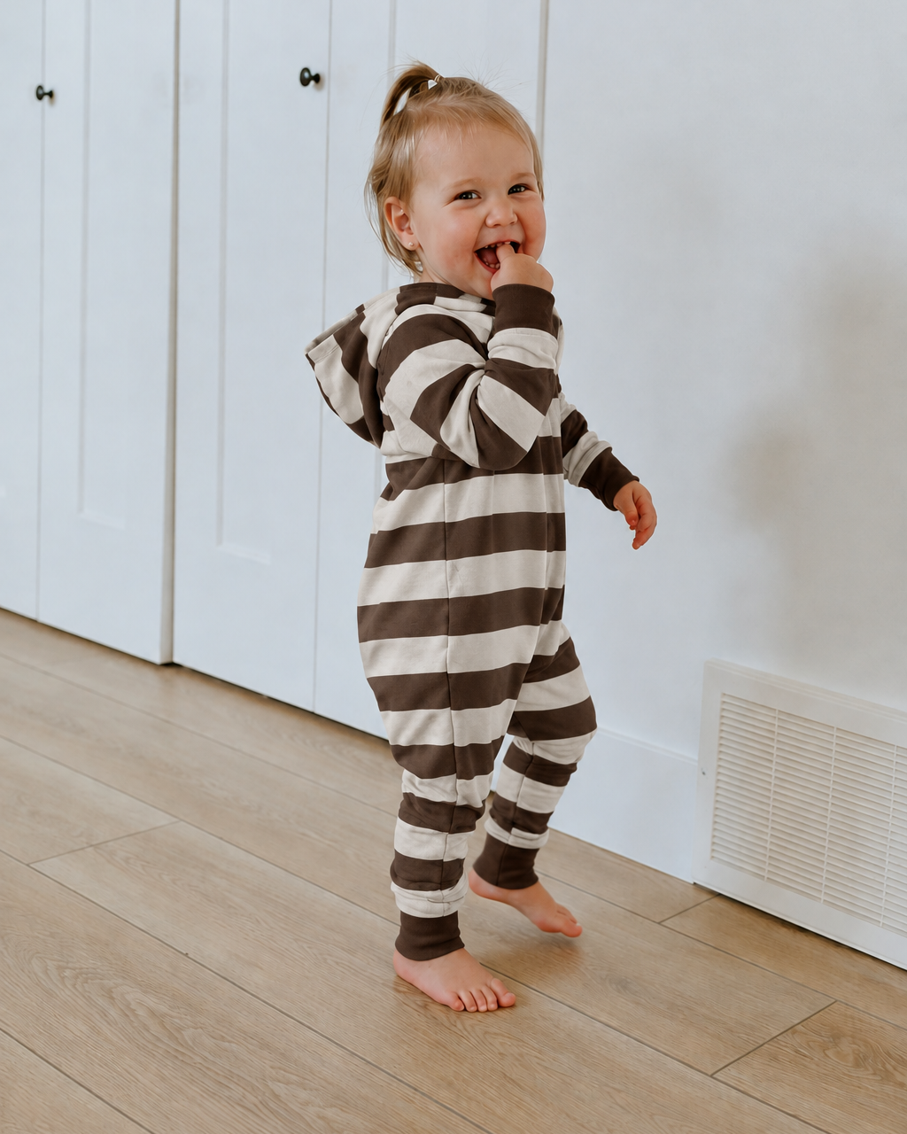 Little girl wearing a navy hooded romper