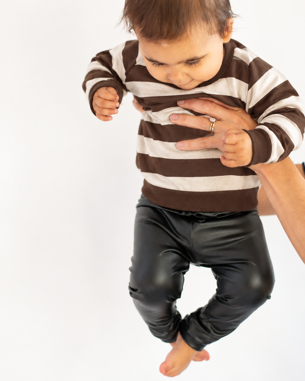 Little girl wearing a brown-and-cream striped sweater