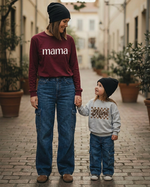 Mom’s burgundy shirt with white mama lettering, standing beside her toddler in the grey Mini sweater