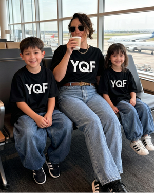 Mother and two children at the airport with matching white YQF lettering on their black shirts