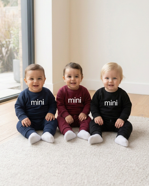 Three babies with white mini lettering