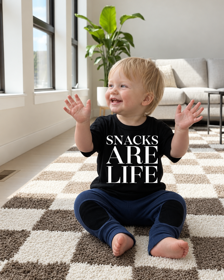 Toddler with warmer skin tones and navy pants looking to the side in the same living room