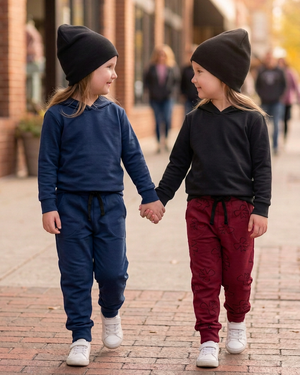 Two girls holding hands, with the right girl in a solid black hoodie and burgundy bow joggers